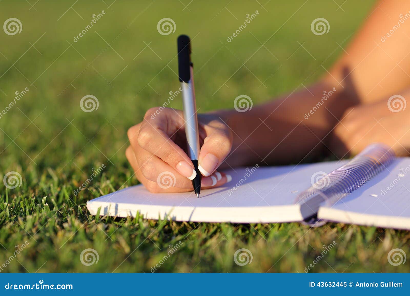 close up of a woman hand writing on a notebook outdoor