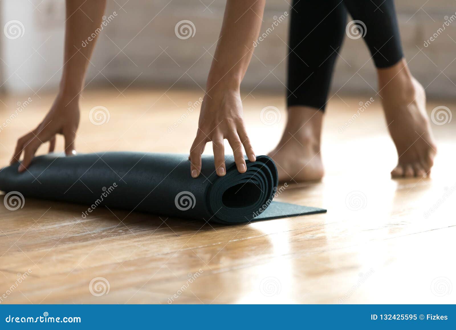Close Up Female Hands Folding Black Rubber Yoga Mat Stock Image