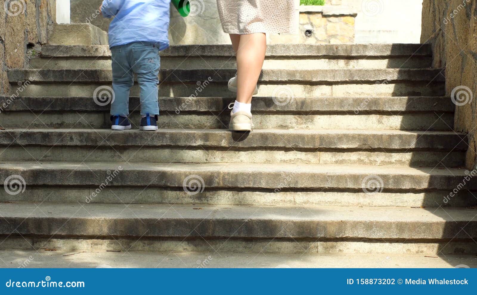 Close Up of Woman Helping Her Little Child Boy To Climb the Stairs by ...