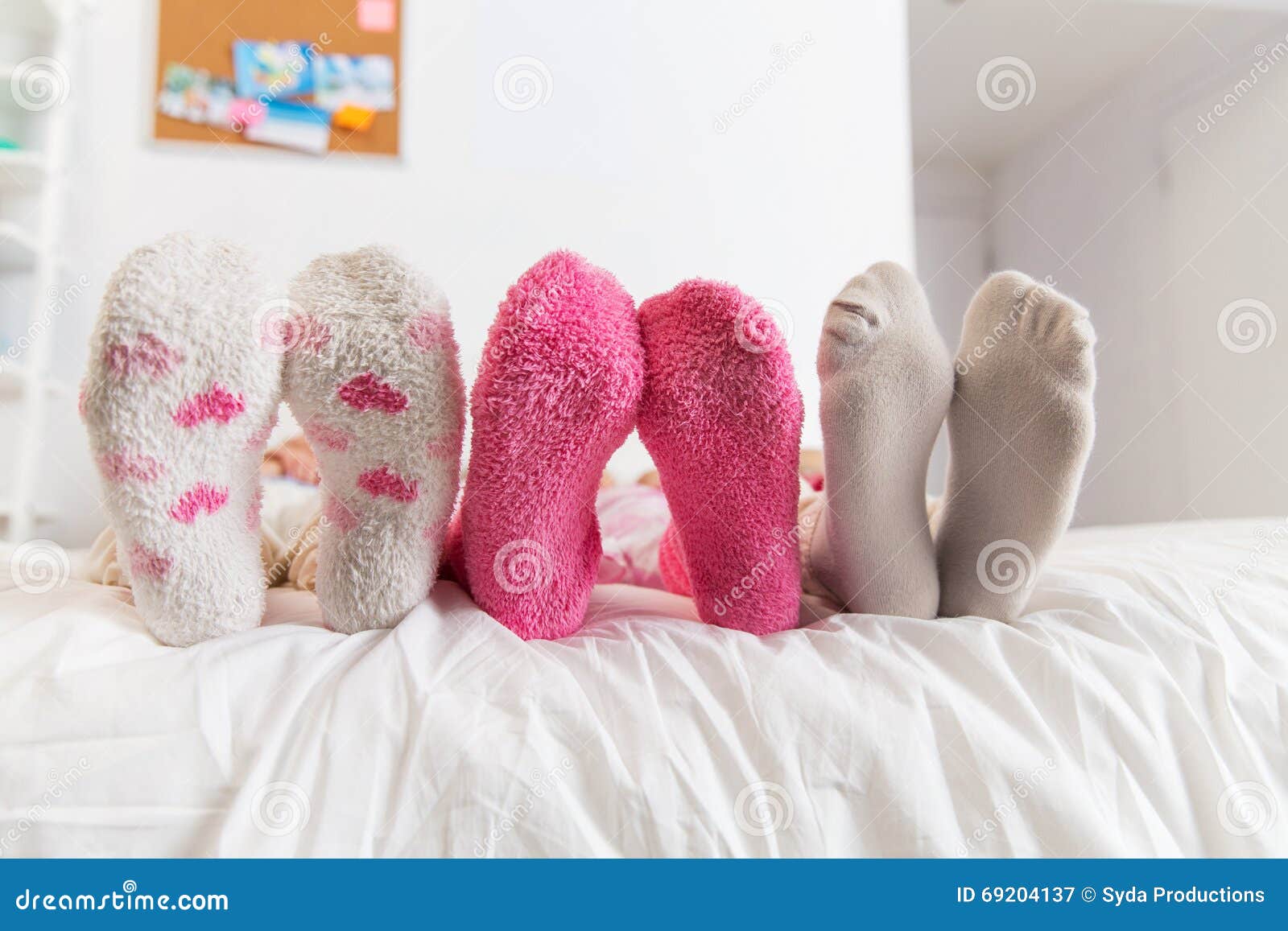 Close up of woman female feet in pink socks on a bed in bedroom relaxing in  the evening Stock Photo