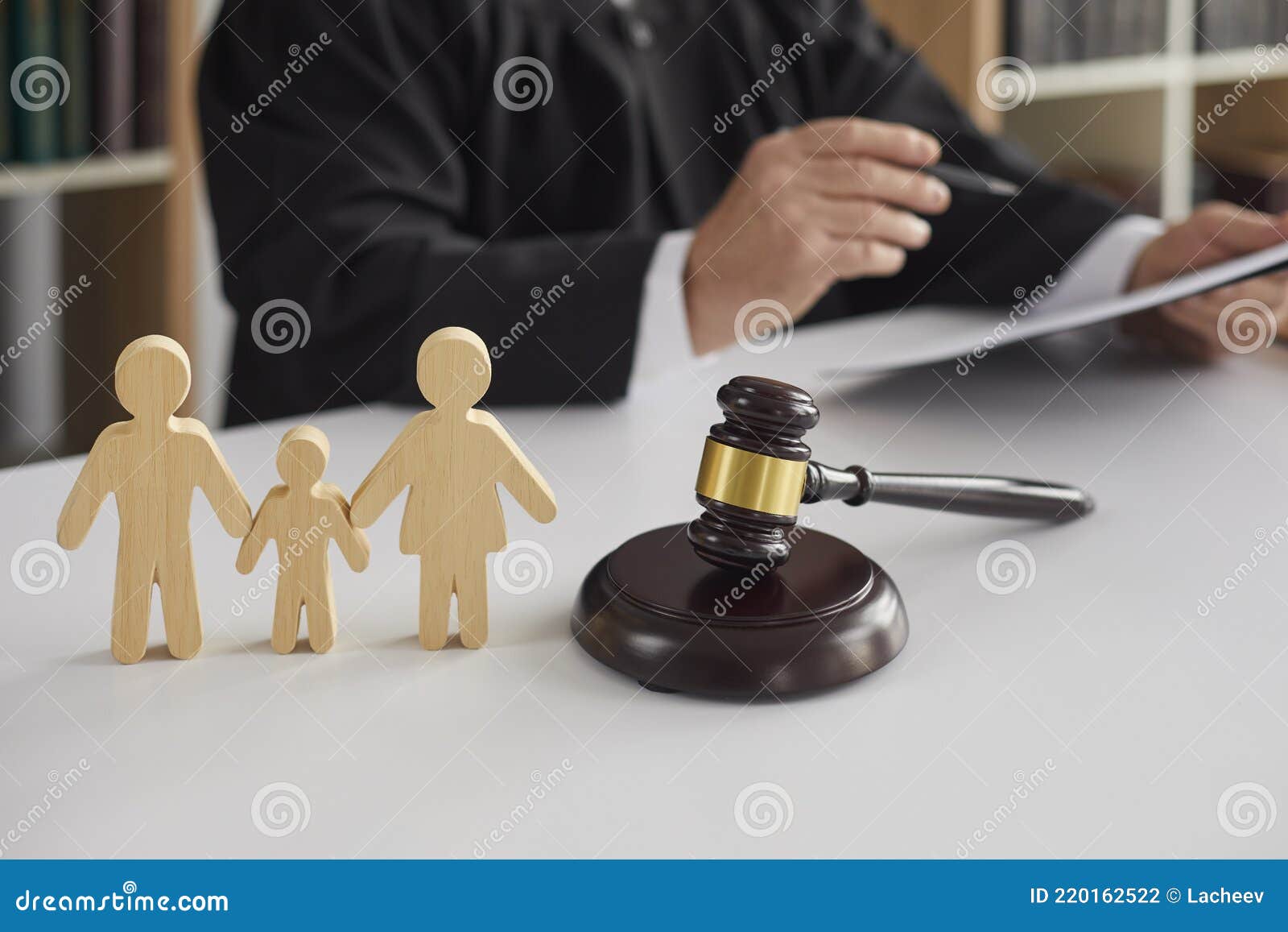 wooden figurines of family with child and gavel on background of judge conducting divorce process.