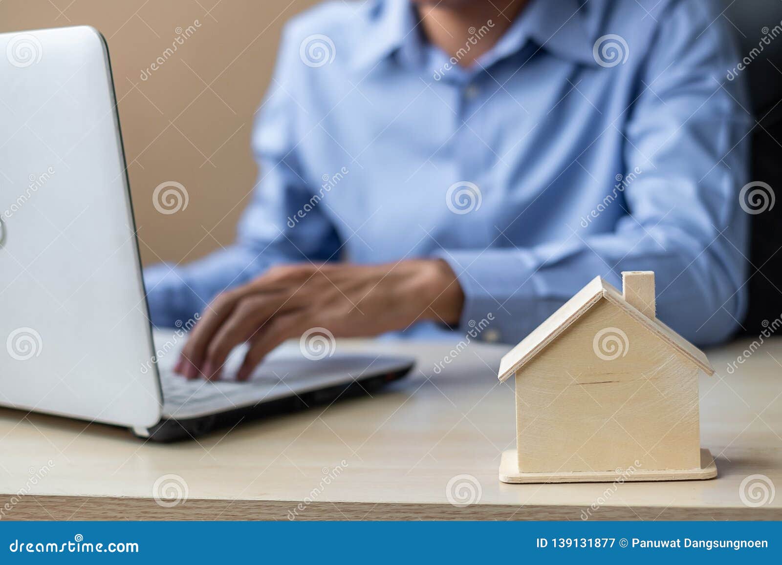 close up wooden house model, businessman using laptop. housing purchase, property, real estate and insurance 