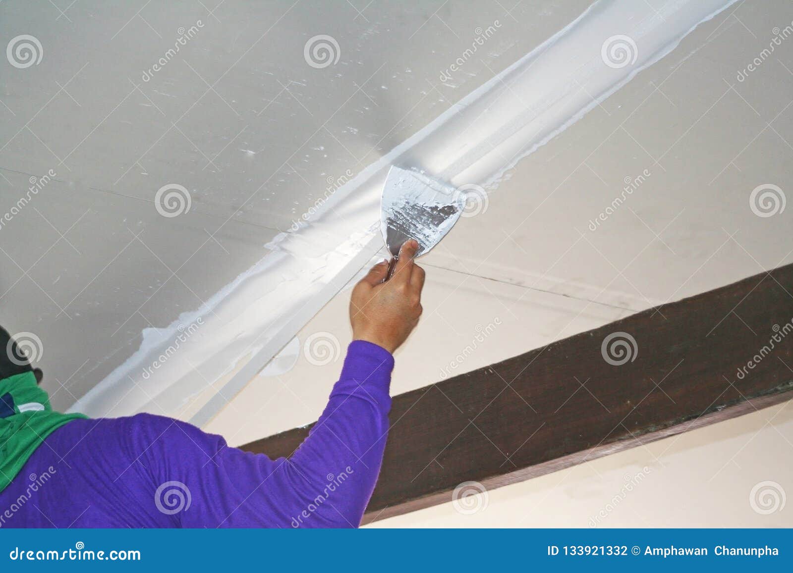 Worker Using Plaster Gypsum On Putty Knife At Ceiling Stock Photo