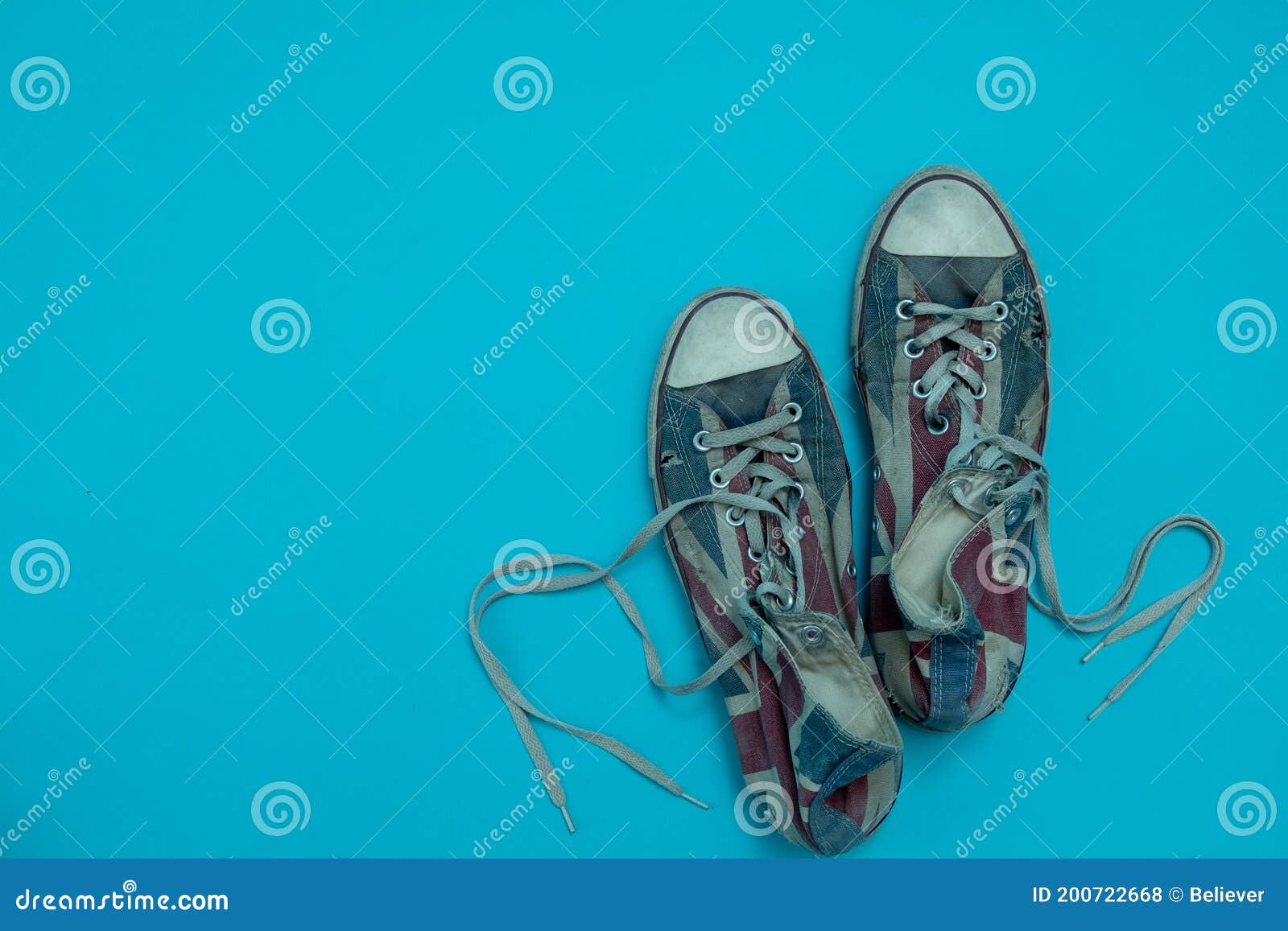 Close Up Worn and Torn Sneakers Isolated on Blue Background. Top View ...