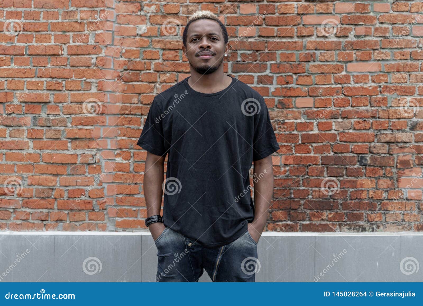 young attractive dark-skinned man in black t-shirt on red bricked background.