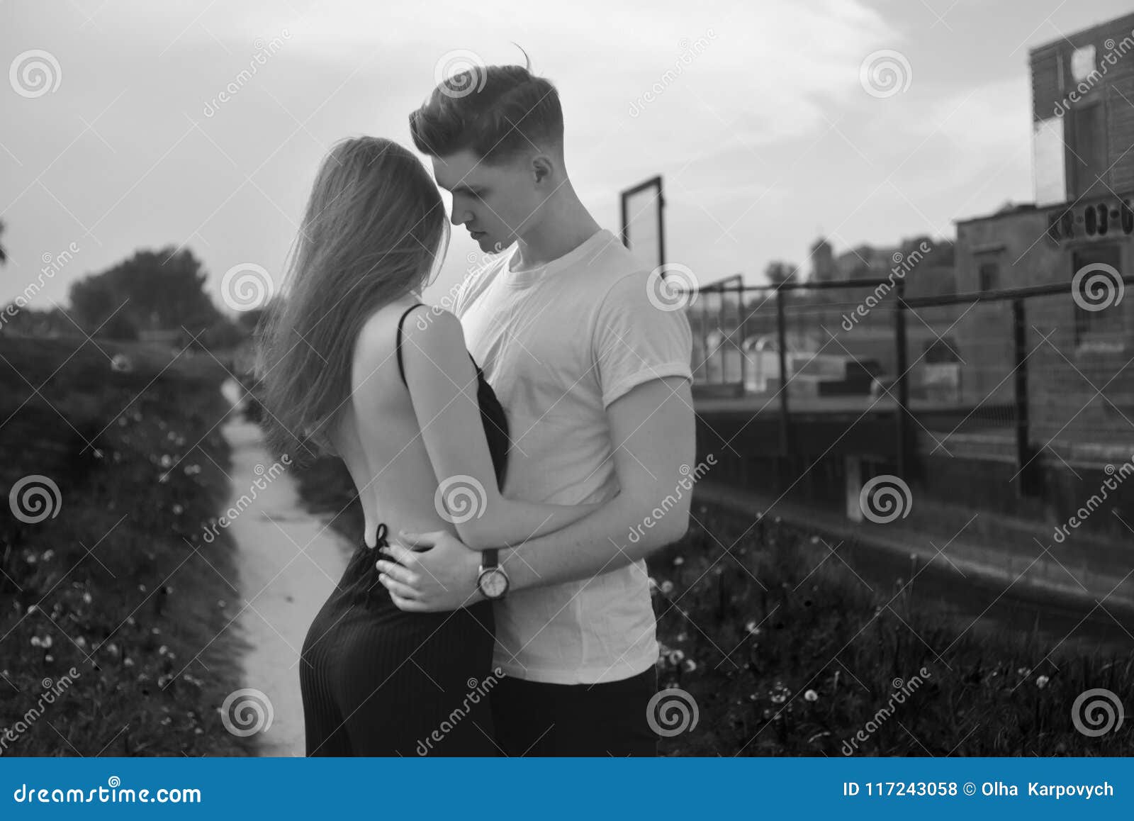 Close up of young romantic couple is kissing and enjoying the company of each other in black and white young couple in love hug each other girl in black