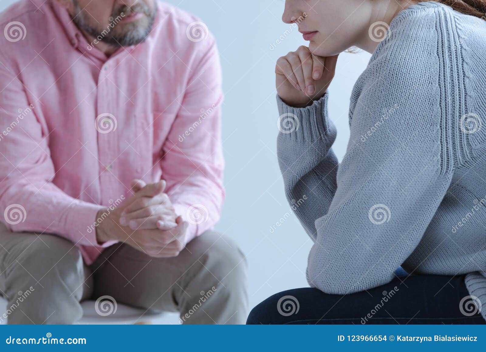 close-up of a young sad woman sharing her grief with a psychotherapy specialist during an individual counseling meeting.