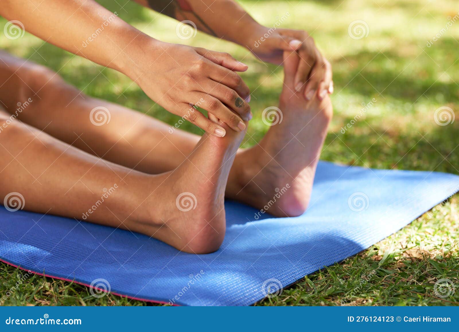 Close Up of Young Woman Flexing Feet, Stretching on Yoga Mat Outdoors