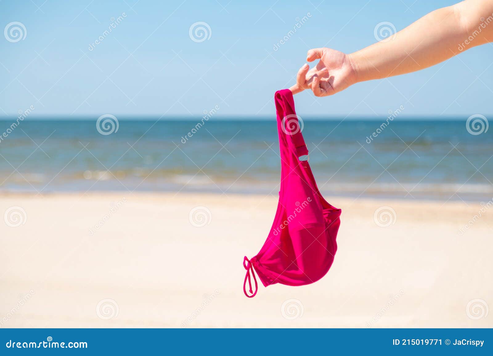 Close Up Of Young Woman Taking Off Her Bra At Nude Beach Concept Of