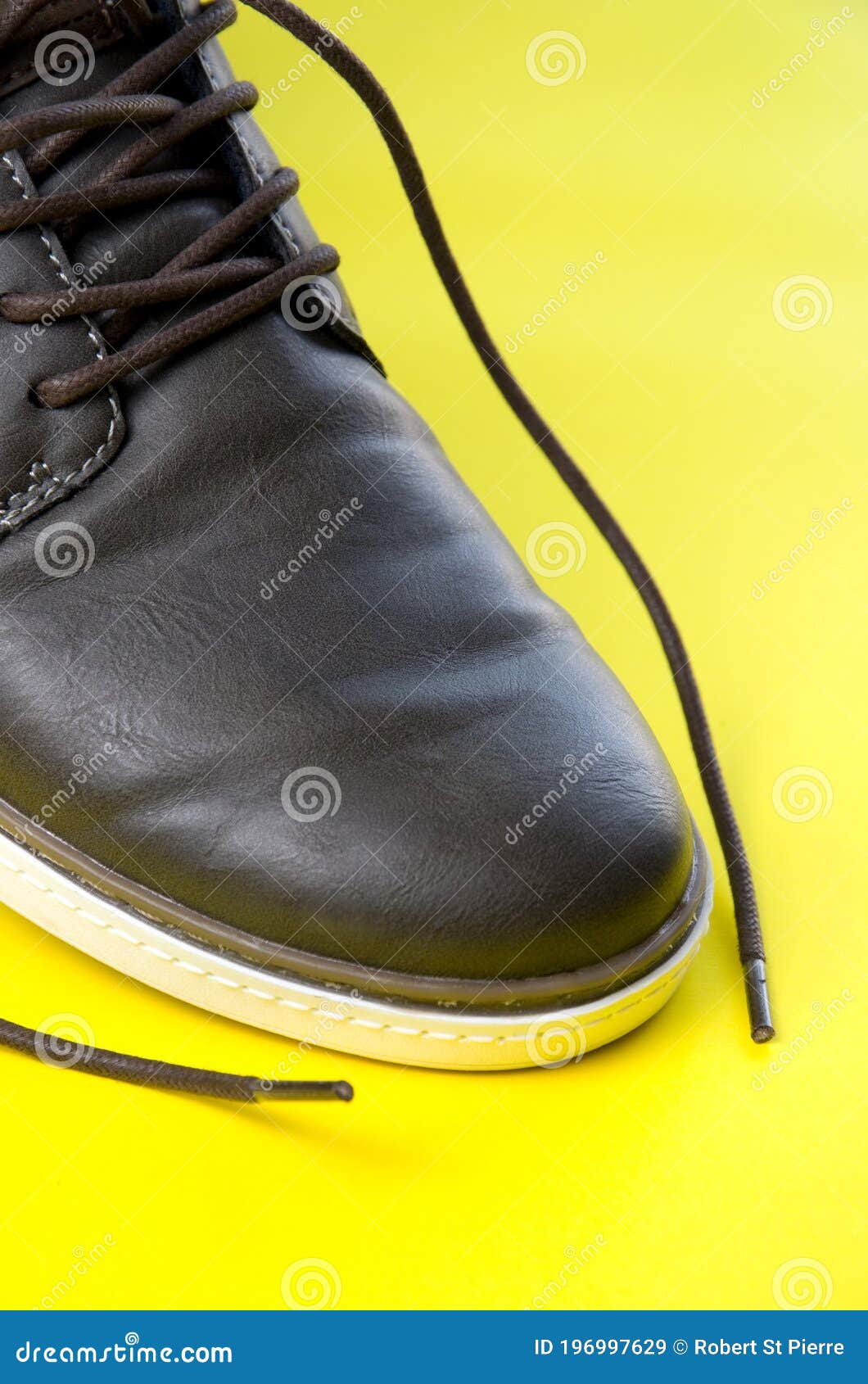 Close View of Synthetic Leather Brown Shoe with Yellow Background Stock ...