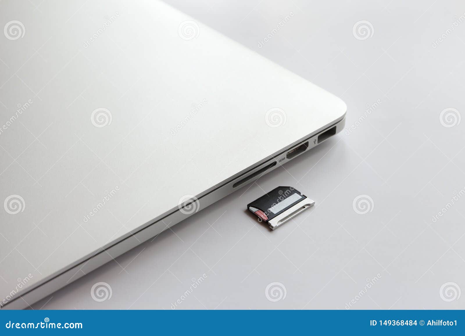 closed metal laptop on a white table. near the adapter to the card reader.