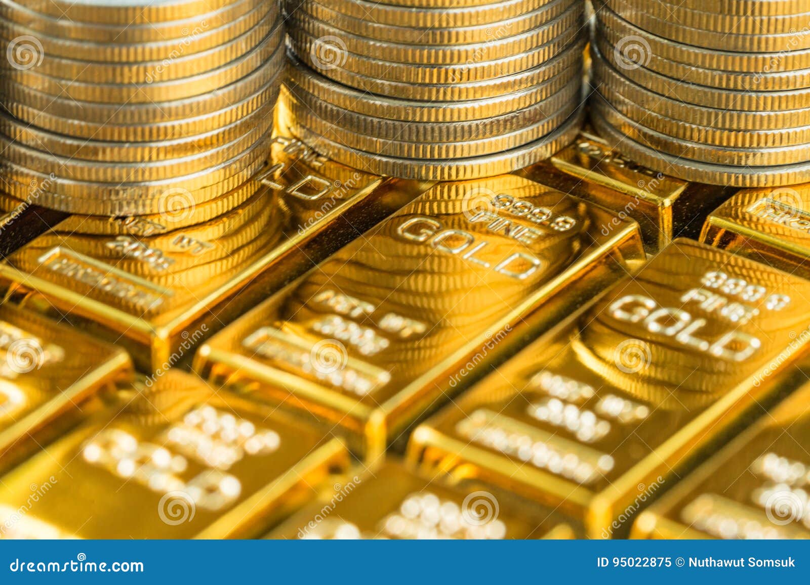 closed up shot of shiny gold bars with stack of coins as business or financial investment and wealth concept