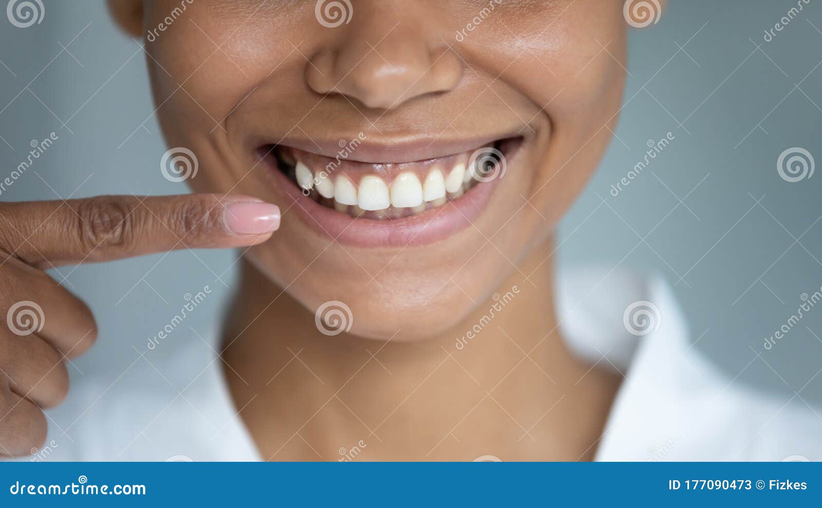 closeup african woman point finger at perfect white toothy smile