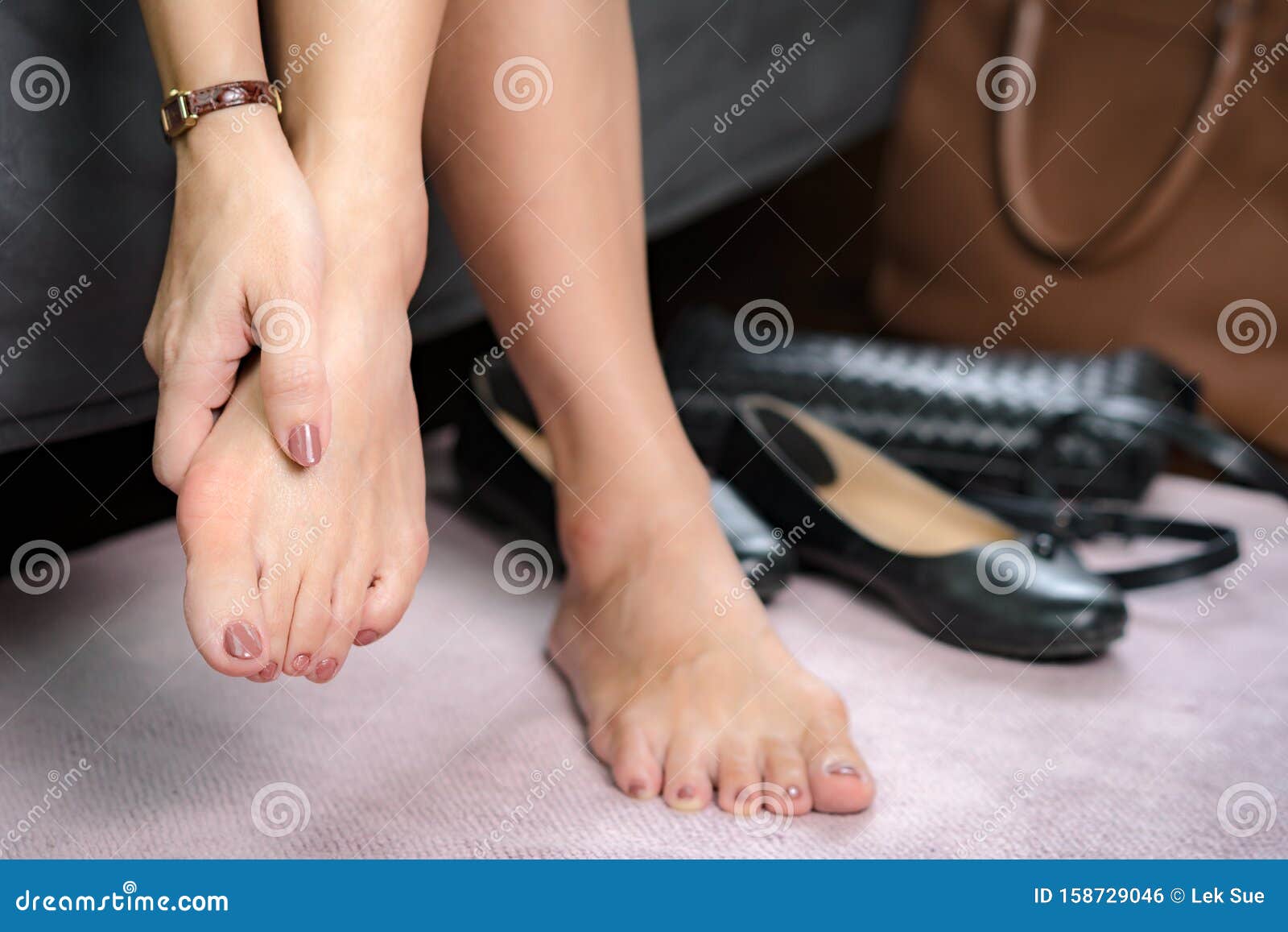 bare feet of working woman, she touching her toes to release pain