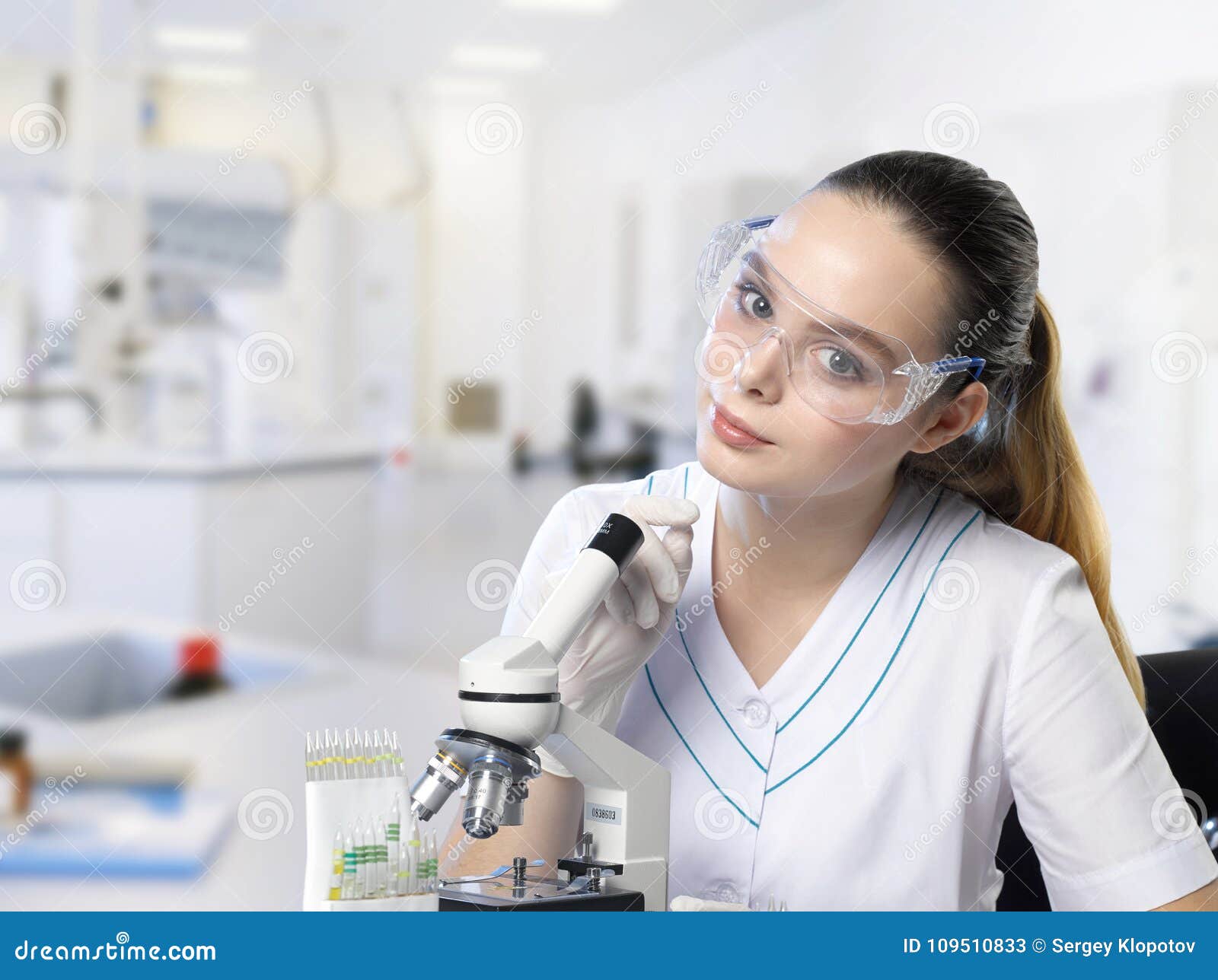 Closeup of a Beautiful Lab Assistant Girl in Glasses with a Microscope ...
