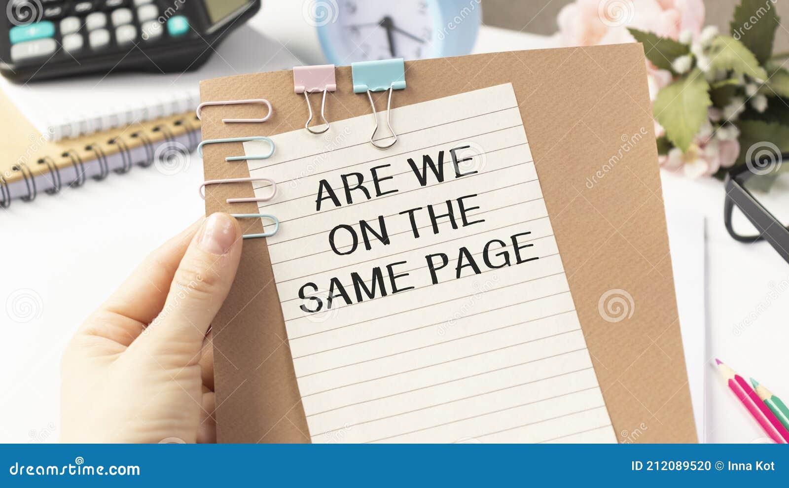 businessman holding a card with are we on the same page message, business concept image with soft focus background and