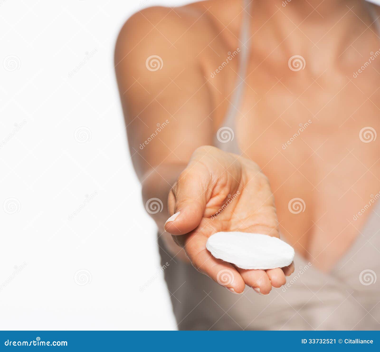 Closeup on cotton pad in hand of woman isolated on white