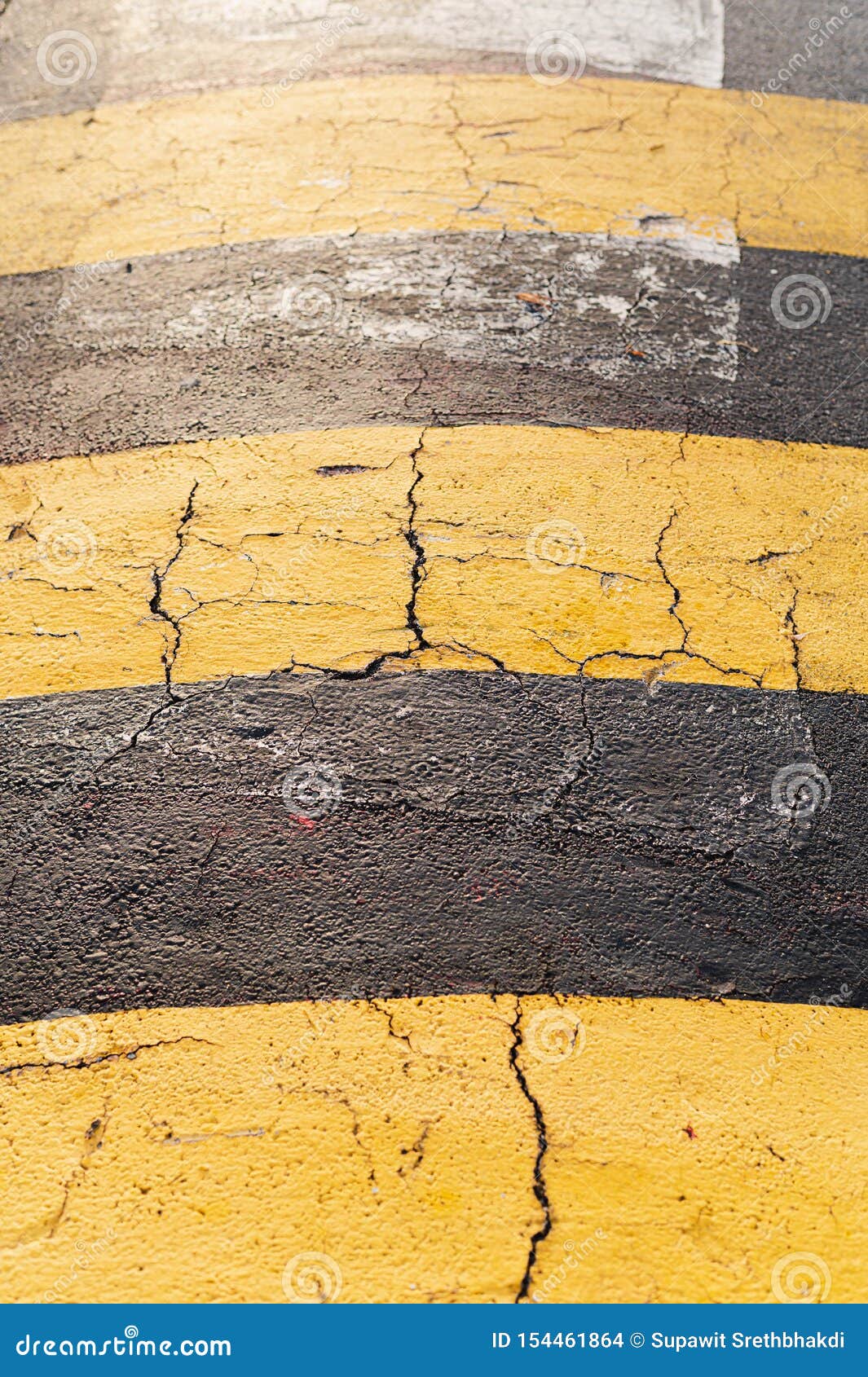 Closeup Cracked Yellow Stripes Concrete Speed Bump With Yellow Sunlight