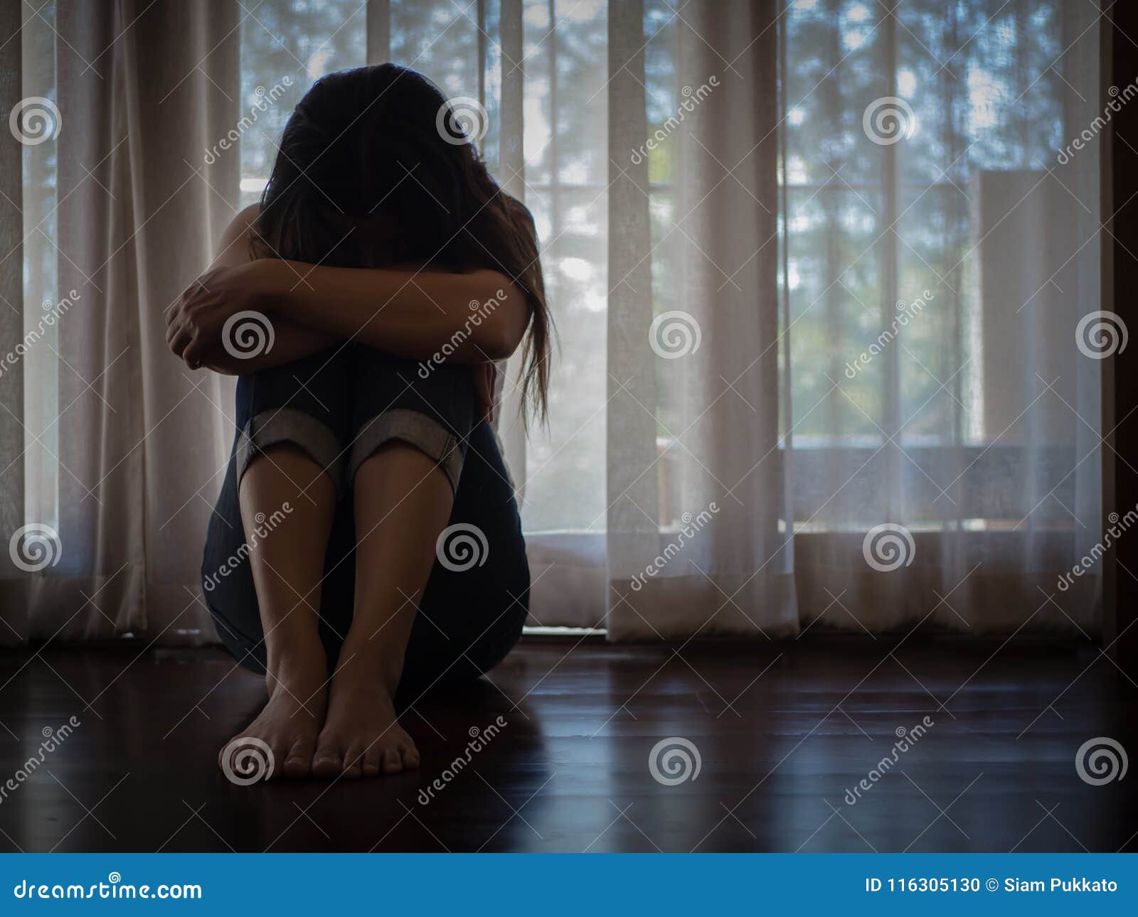 closeup despaired woman hug her knee and cry while sitting alone