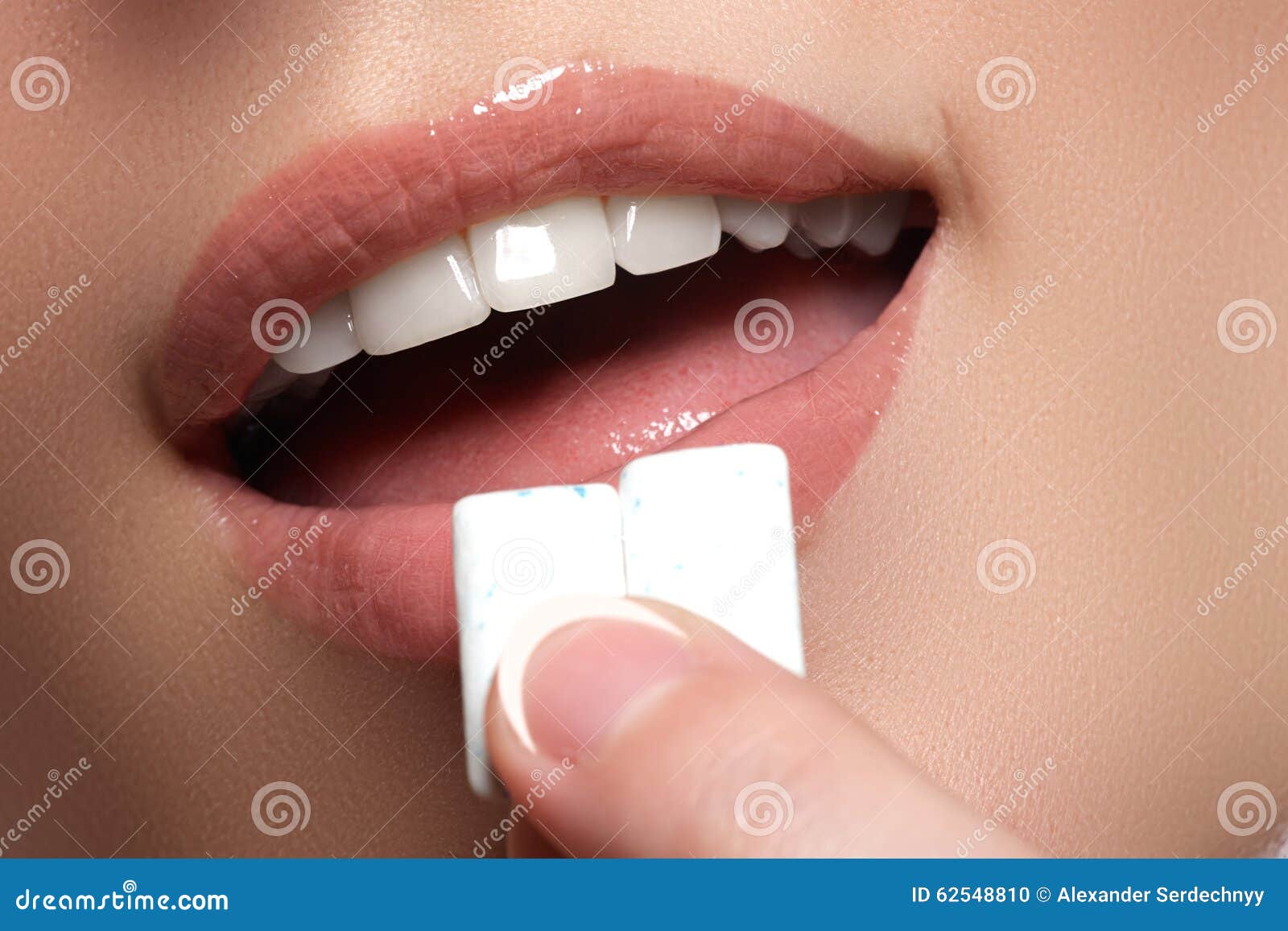 closeup detail of woman putting pink chewing gum into her mouth. chewing gum, eating, women. close up on a beautiful girl