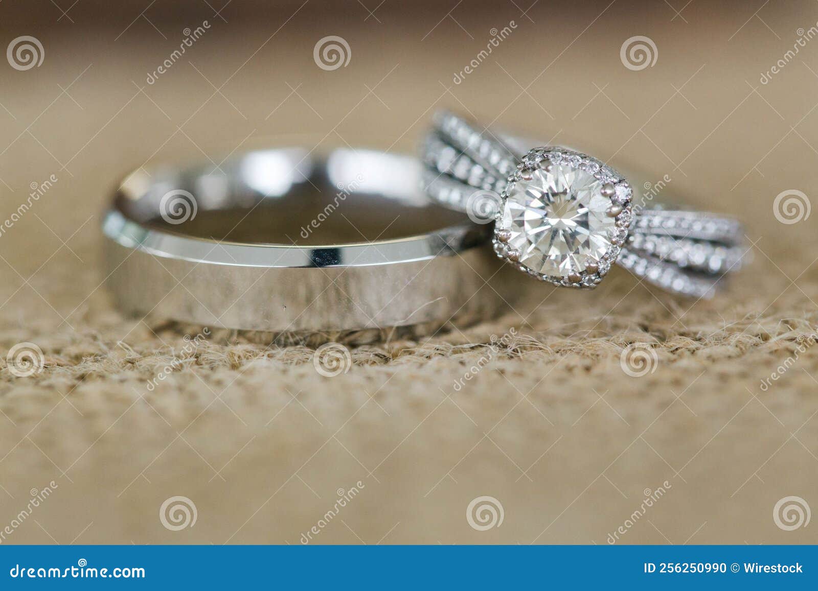 Closeup of a Diamond Stone Ring Over a Plain Silver Wedding Ring Stock