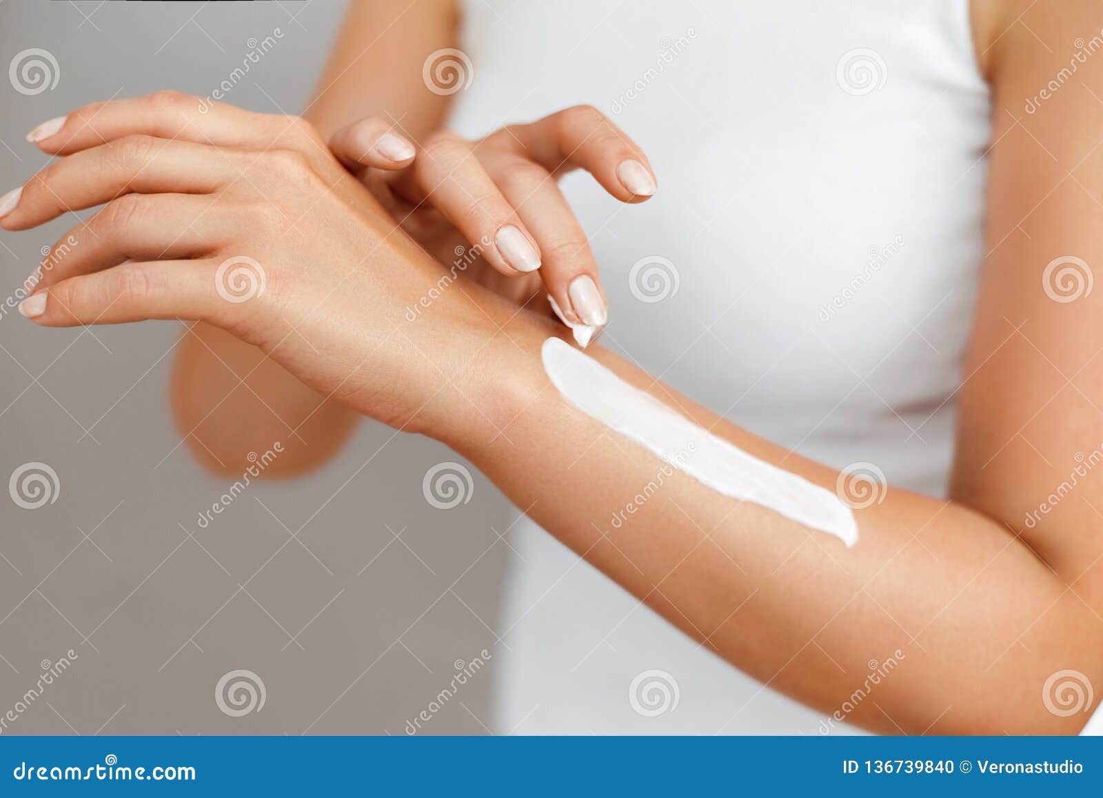 closeup of female hands applying hand cream.hand skin care. women use body lotion on your arms. beauty and body care concept.