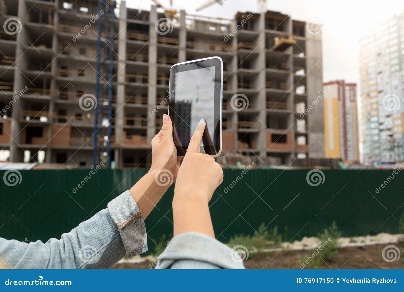 Closeup of Female Realtor Using Digital Tablet at Building Under Stock