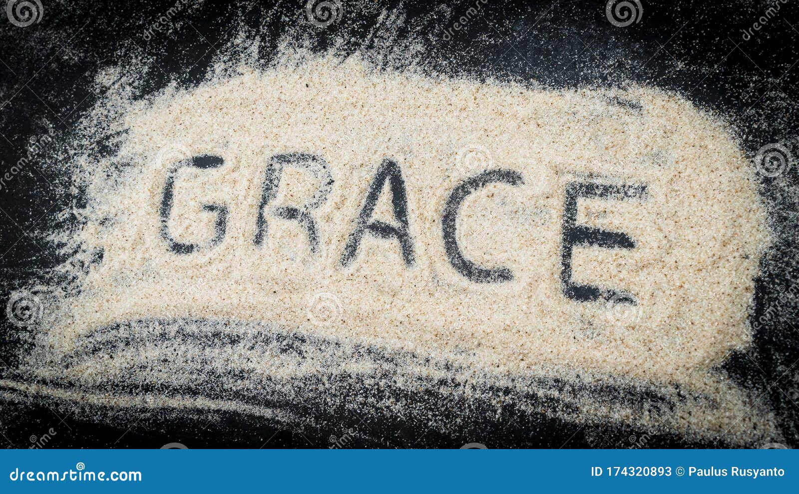 closeup of grace word written on white sand