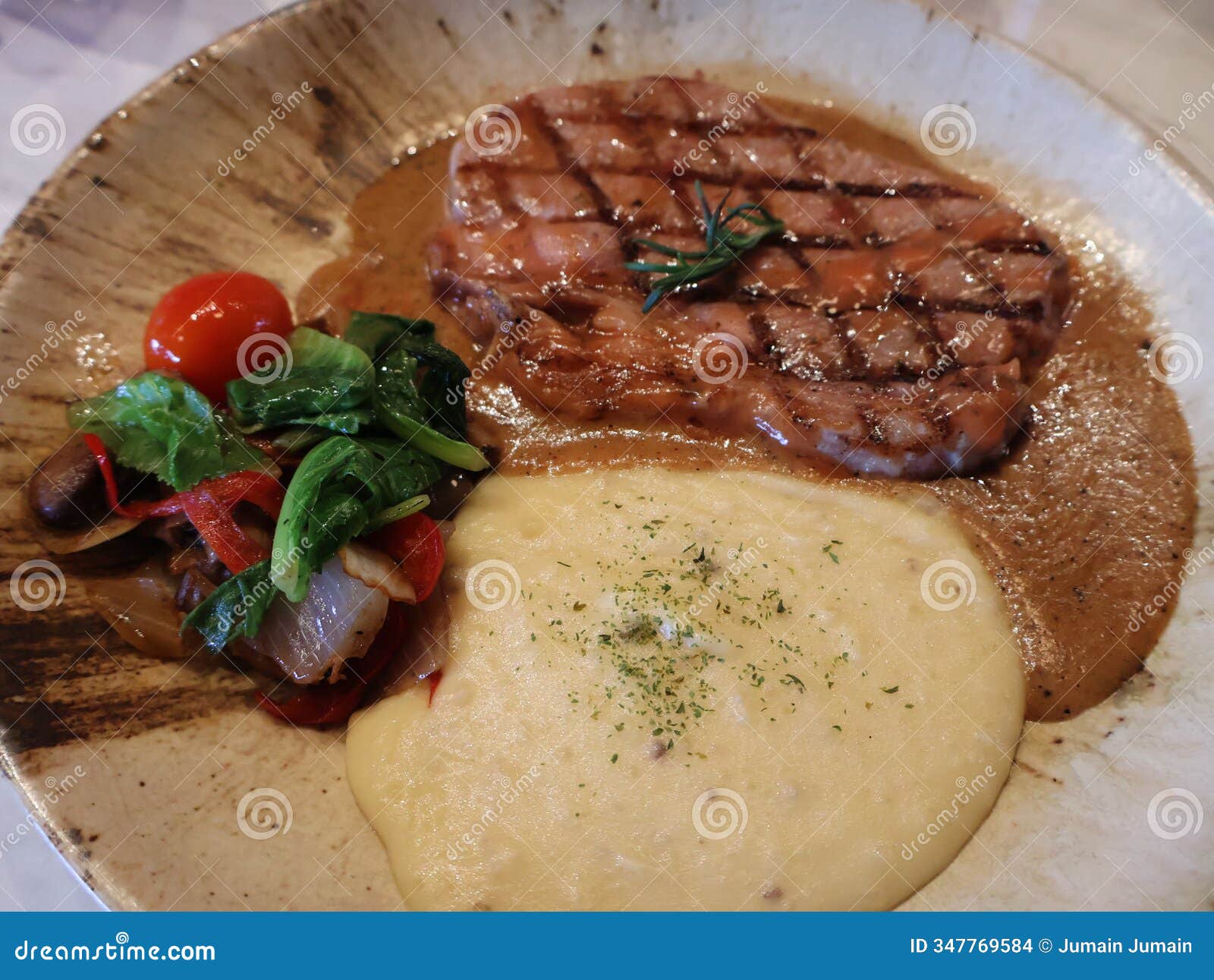 closeup of grilled rib eye beef steak served with mash potato and vegetables