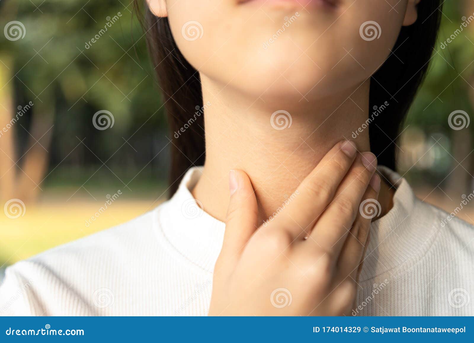 closeup of hands of asian female people holding her inflamed throat or tonsillitis,child girl touch the neck with her hands,woman