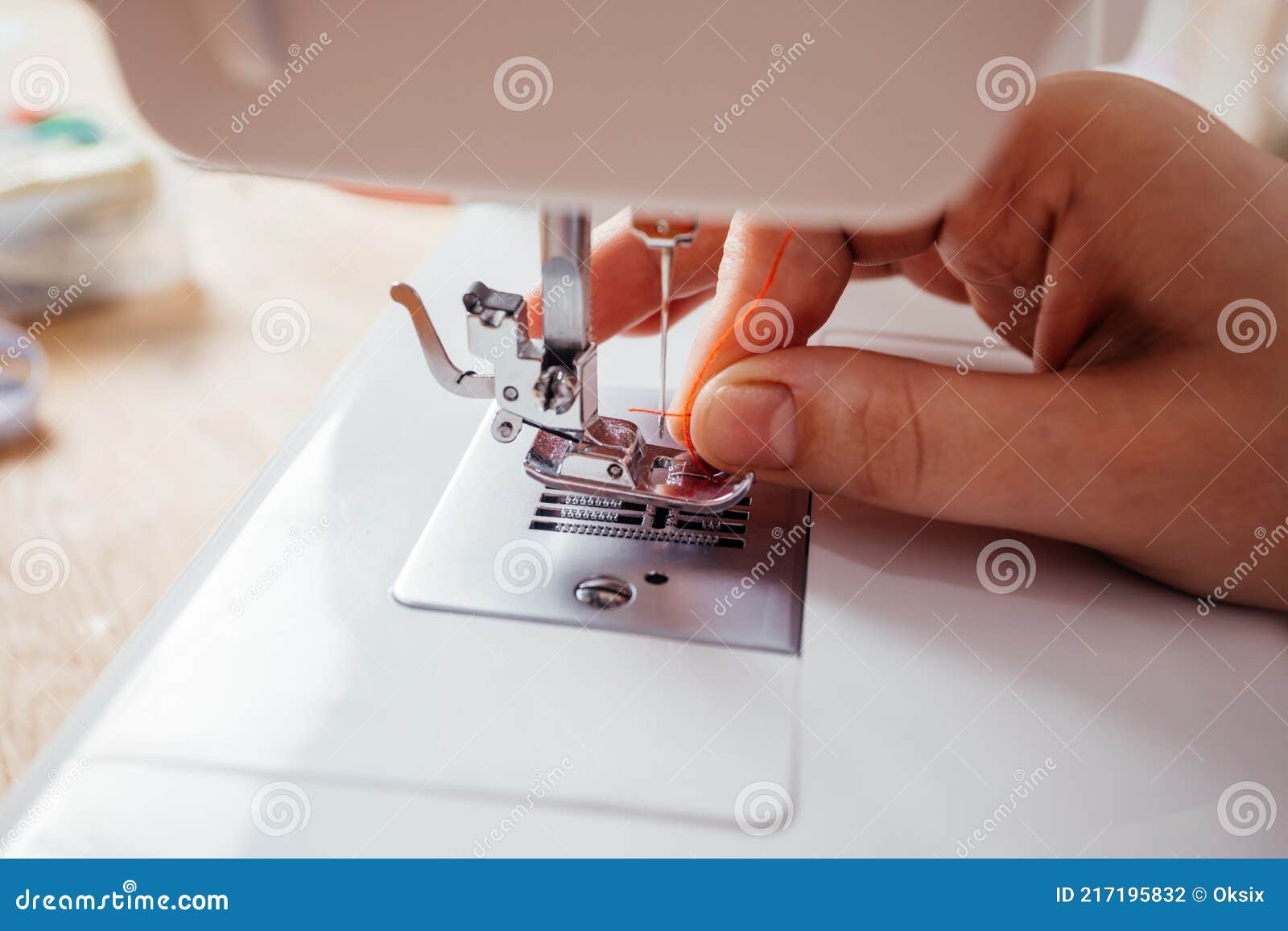 Closeup Hands Inserting Thread into Sewing Machine Needle Stock Photo