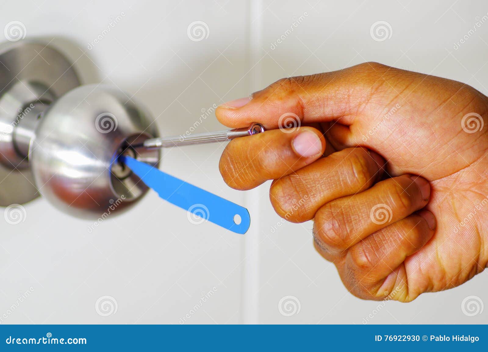 Closeup Hands Of Locksmith Using Pick Tools To Open Locked