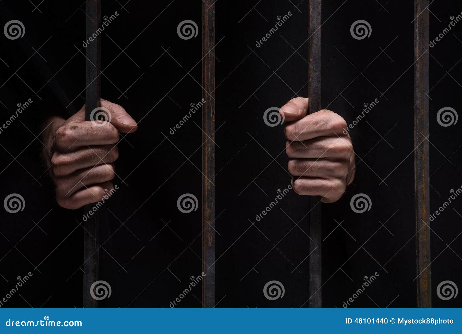 closeup on hands of man sitting in jail.