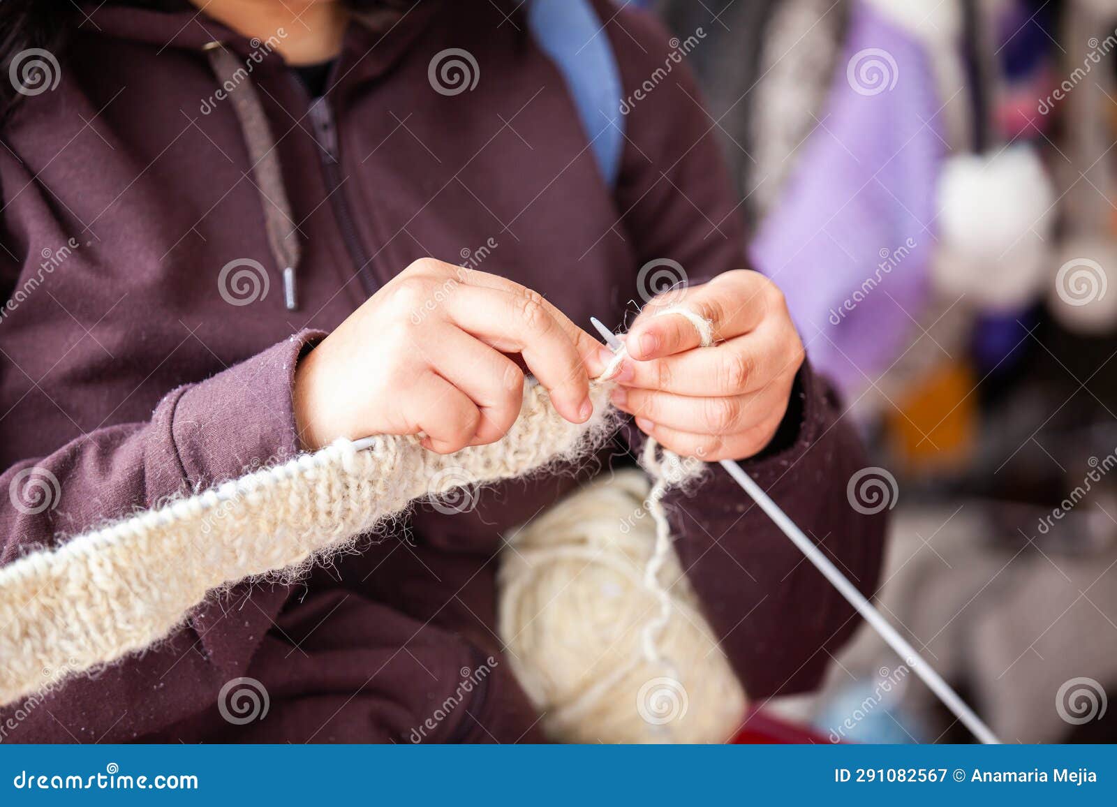 closeup of the hands of a woman weaving a traditional ruana from the town of nobsa in the department of boyaca in colombia