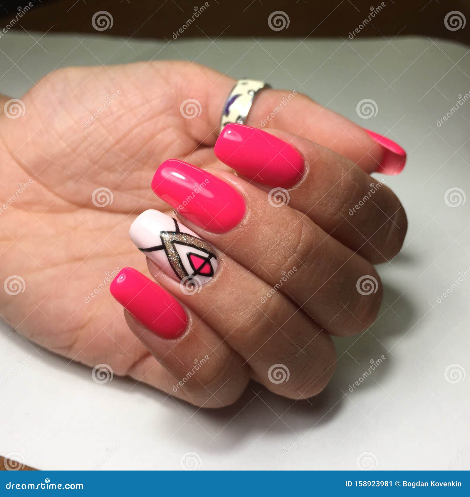 female hands with stylish red manicure on grey background
