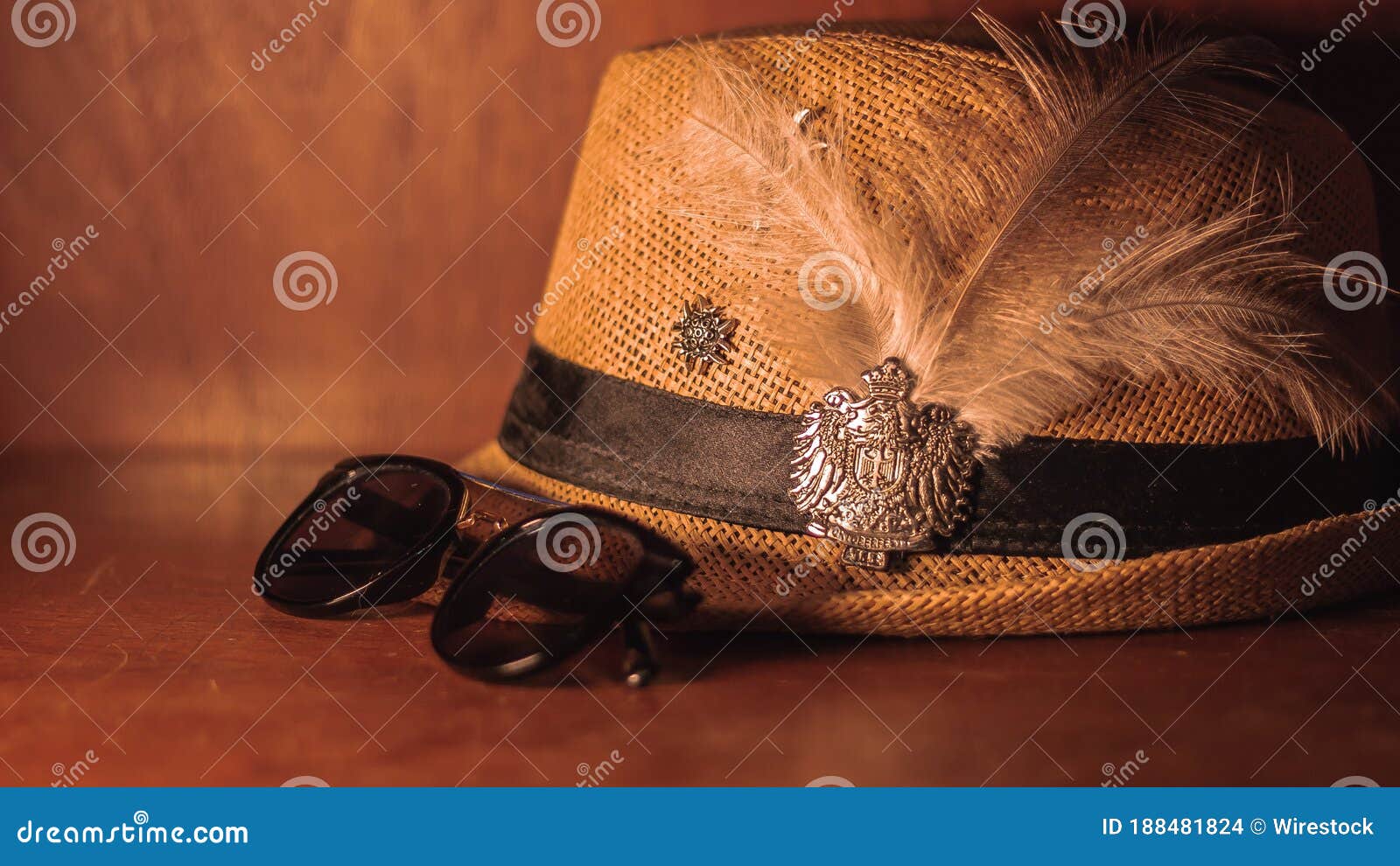 closeup of a hat with feather next to the glasses