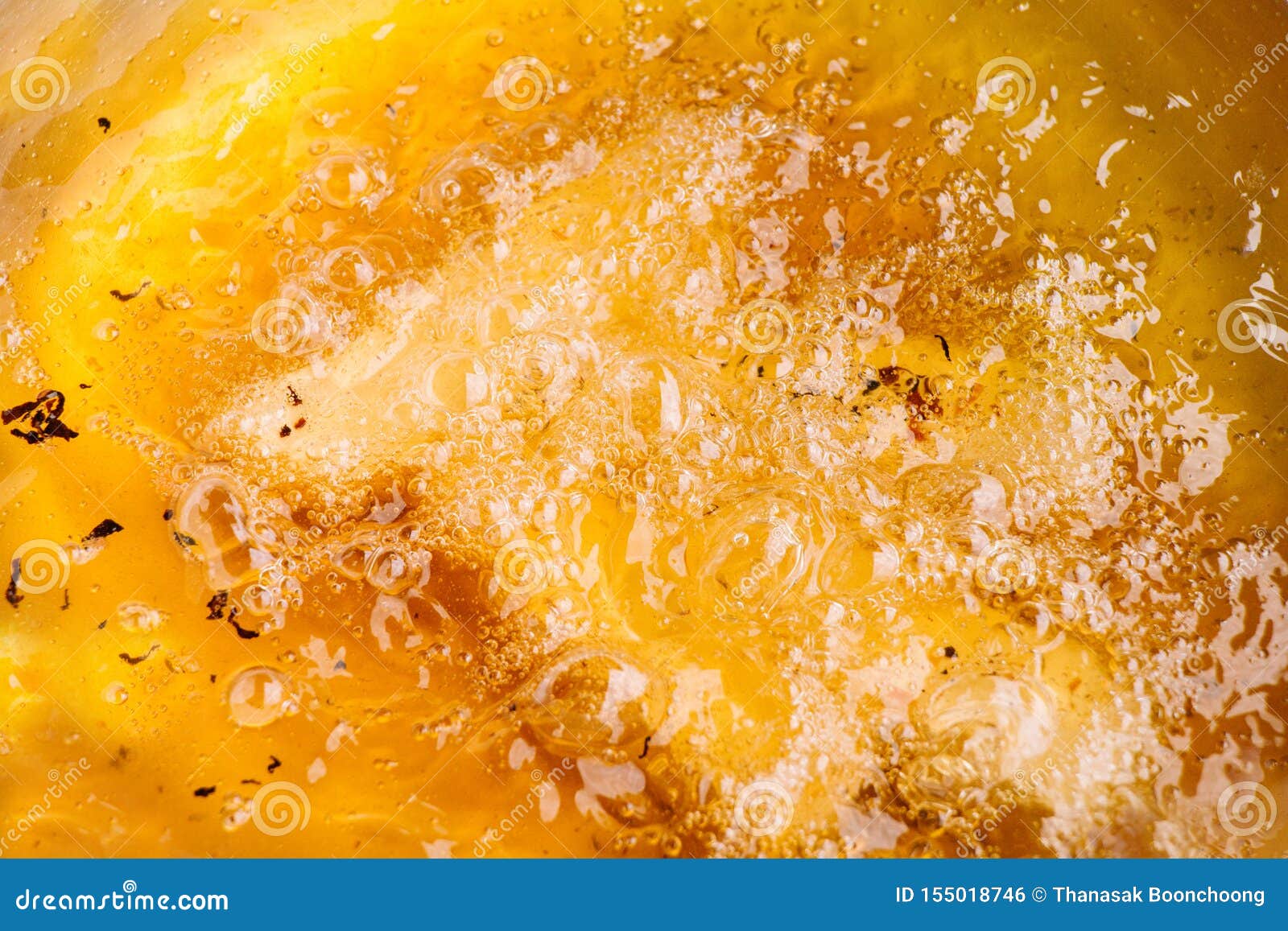 closeup of hot bubbling boiling oil in a deep fryer