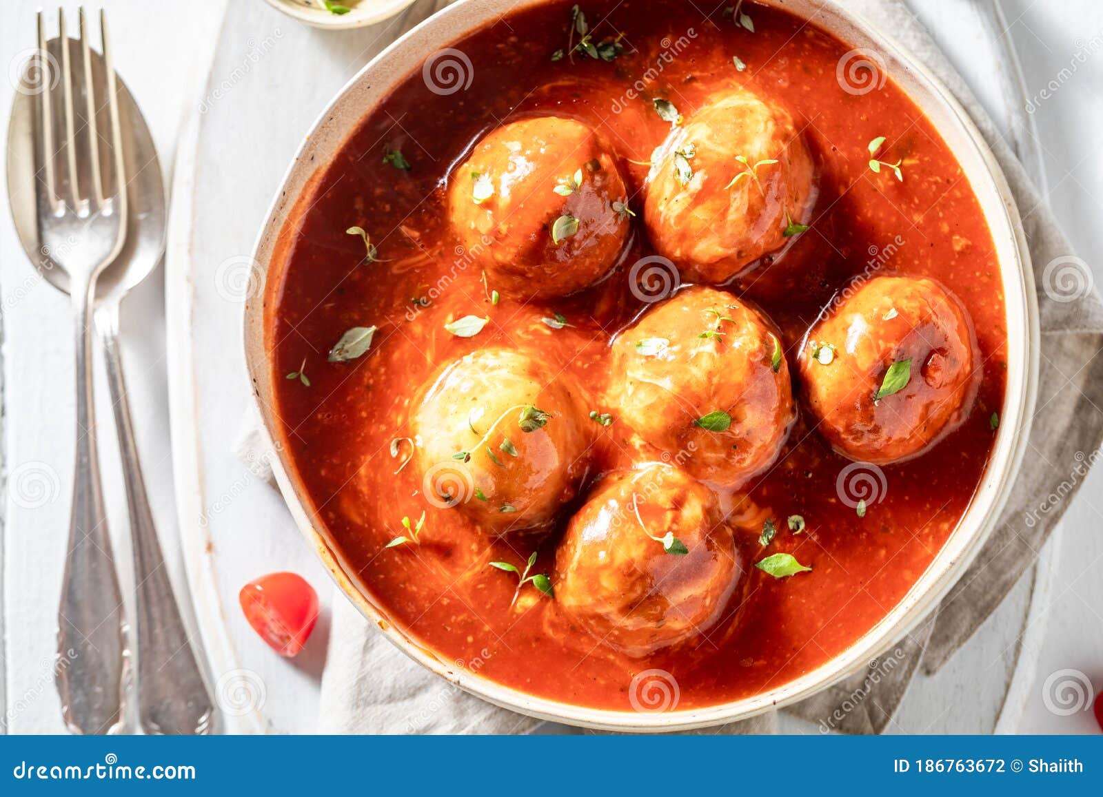 Closeup of Hot Meatballs with Fresh Herbs and Tomatoes Stock Photo