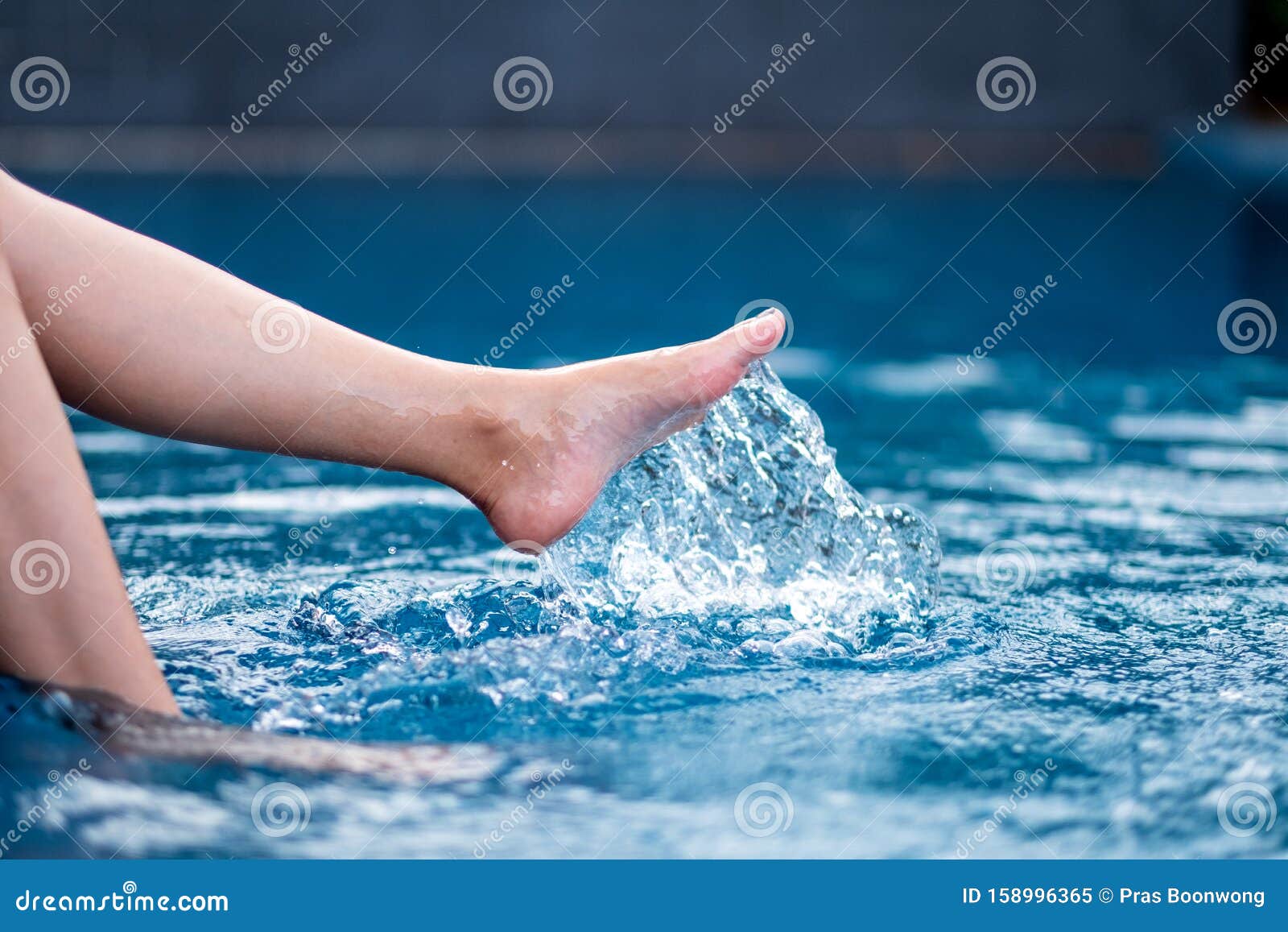 Legs and Left Foot Kicking and Splashing Water in the Pool Stock Image