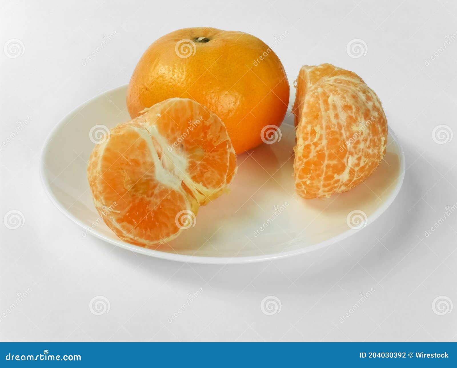 closeup of juicy ripe orange tangerines (citrus reticula) peeled on a plate with a white background