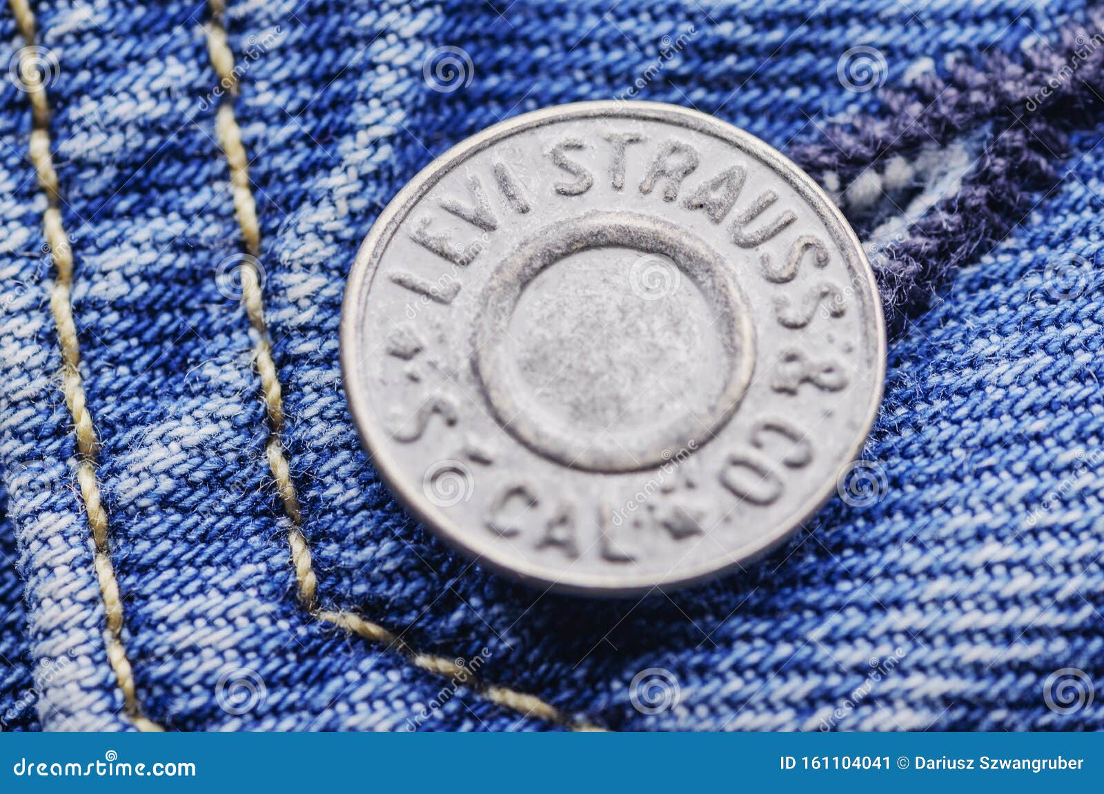 Closeup Of Levi Strauss Button On Blue 