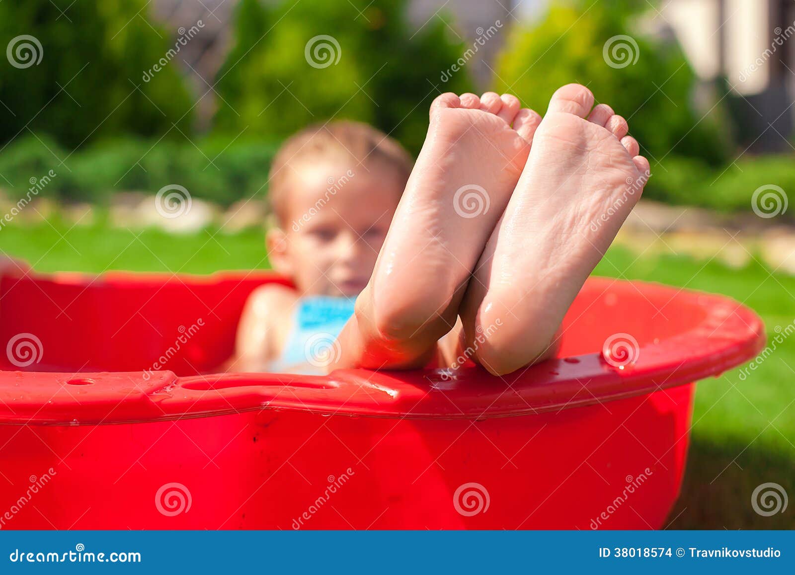 Closeup of little kid s legs in small red pool. This image has attached release.