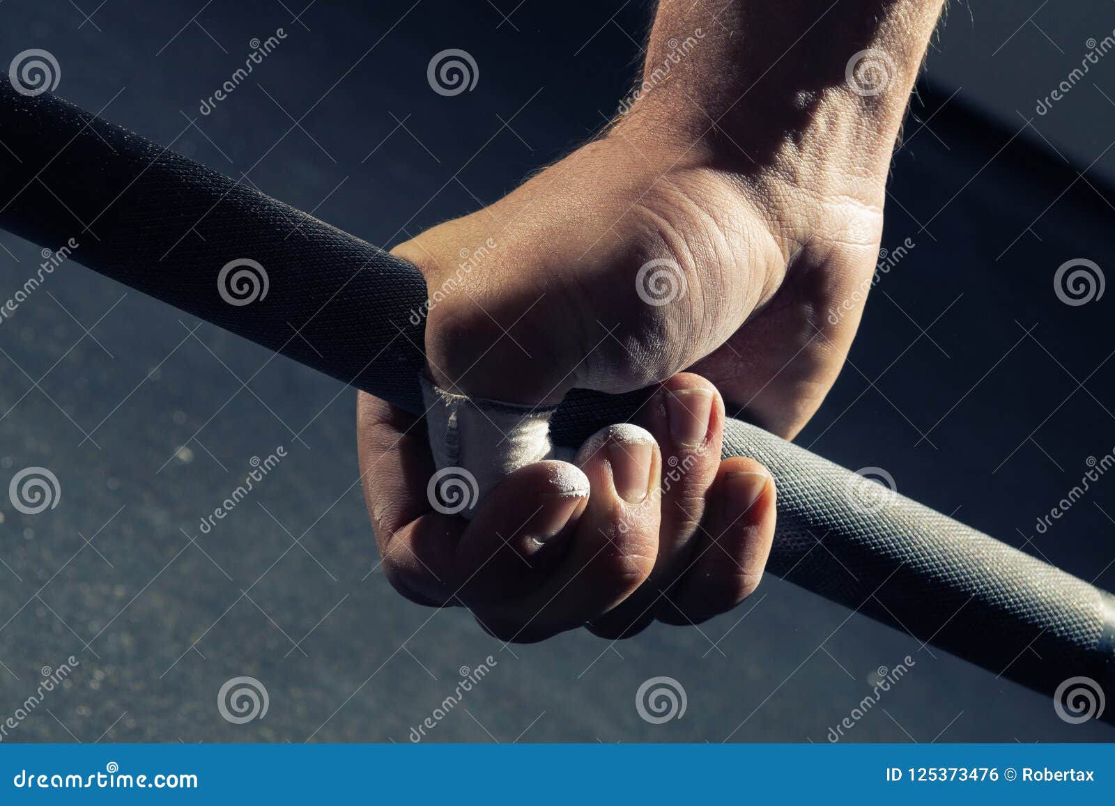 closeup of man`s hand gripping a barbell