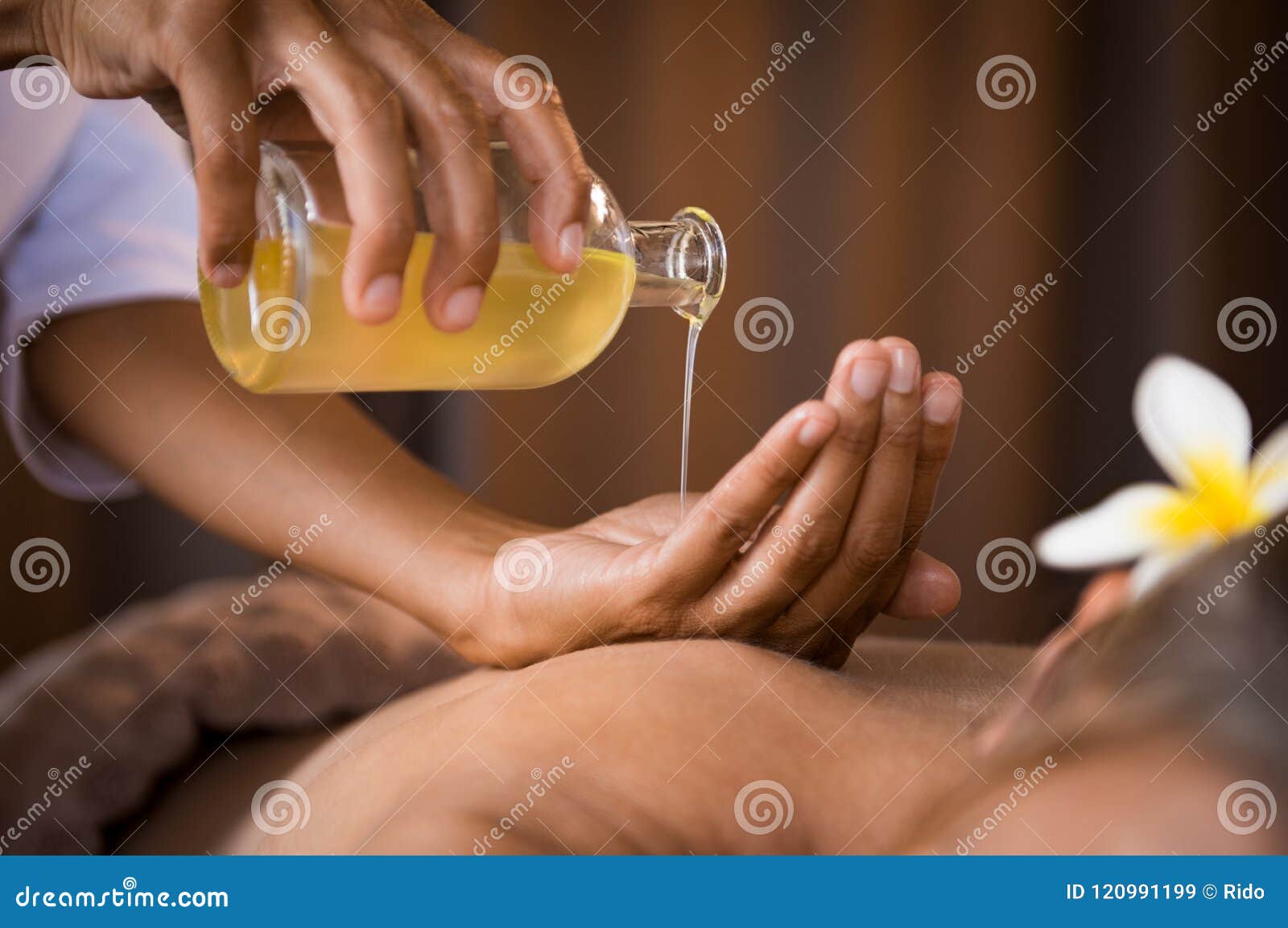 therapist pouring massage oil at spa