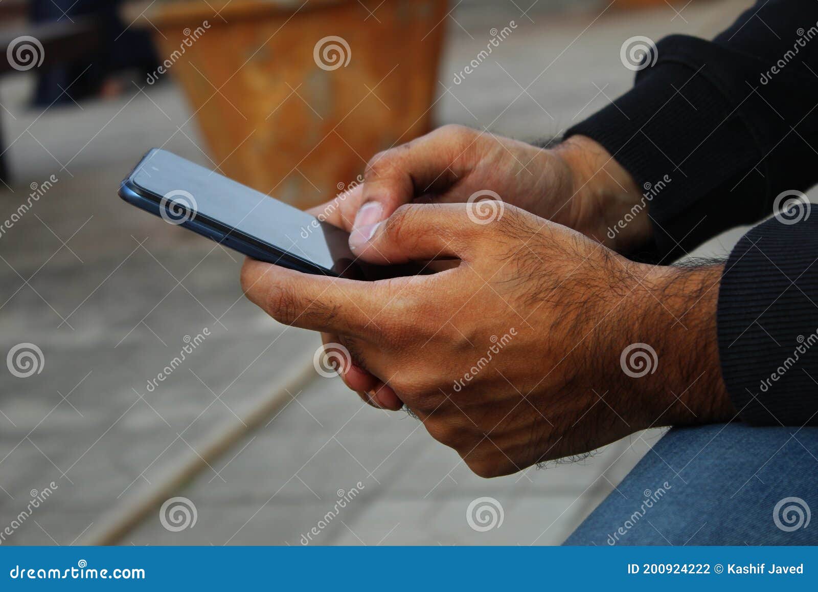 technology closeup dark skin man using phone