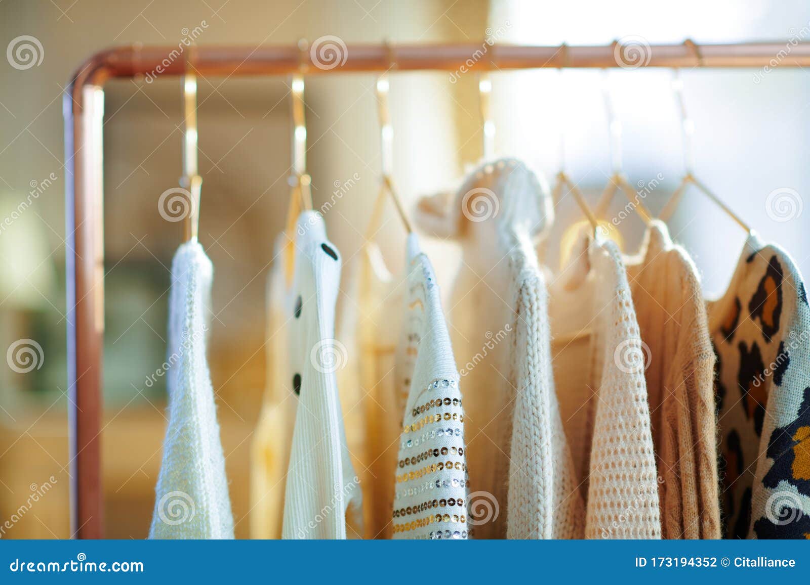 Closeup on Modern Copper Clothes Rack with Clothes on Hangers Stock
