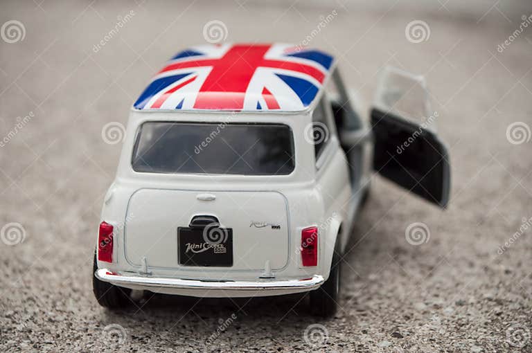 Closeup of Old White Mini Cooper with British Flag on Roof on Stoned Background Editorial