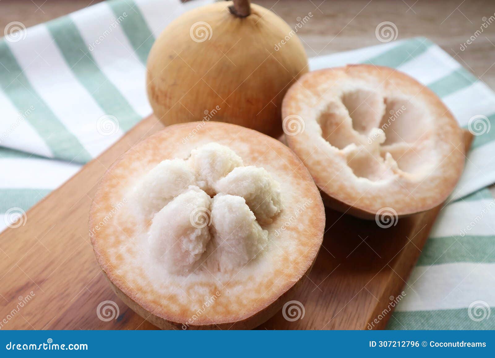 closeup of opened fresh cotton fruit or santol fruit with whole fruit in background