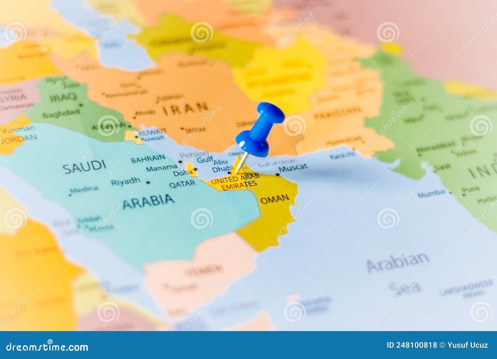 blue push pin pointing at united arab emirates on a political world map