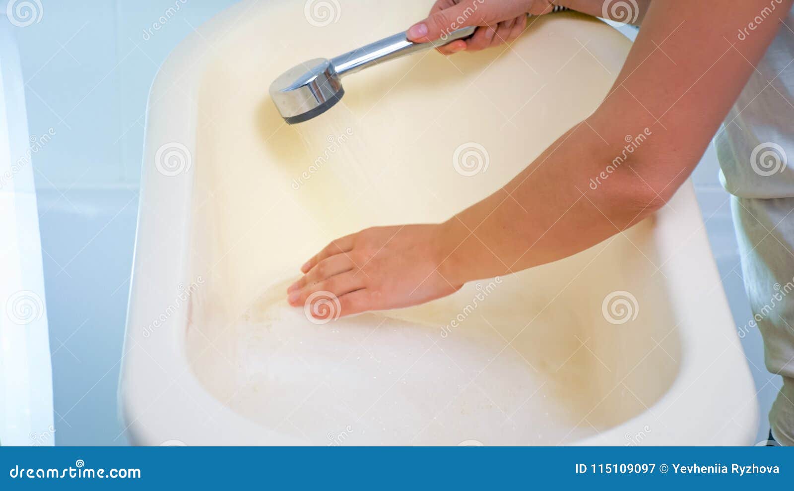 Closeup Image Of Young Woman Checking Water Temperature In Baby Bathtub